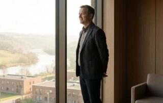 Confident man in modern Albany NY medical consultation suite, representing penis enlargement Albany NY services at Latham clinic.